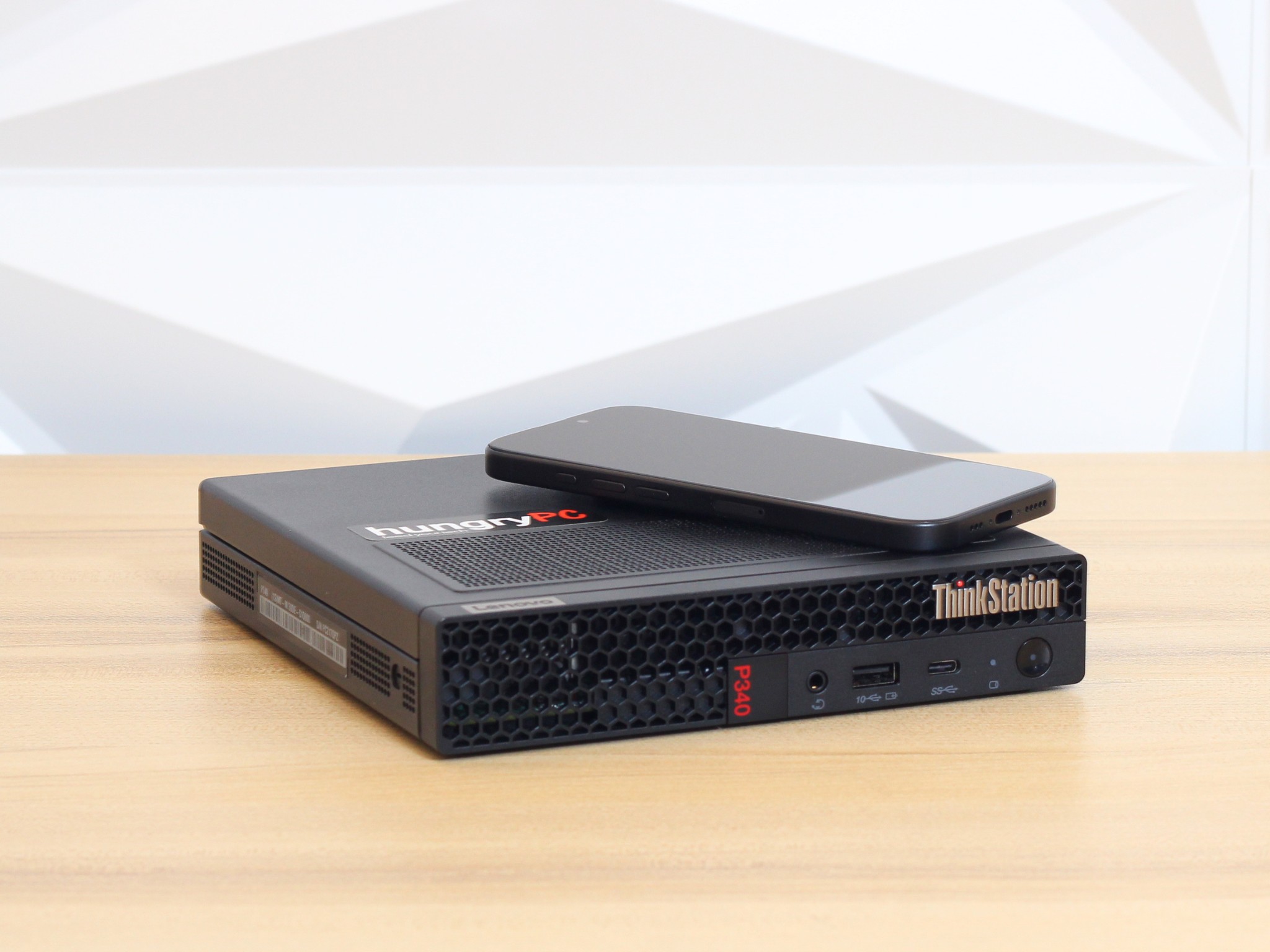 Lenovo ThinkStation P340 Tiny Mini PC iPhone Scale size comparison: refurbished lenovo thinkstation mini pc shown next to an iphone to demonstrate its footprint.
