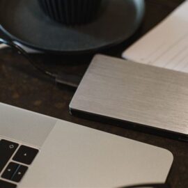 External hard drive beside a laptop for moving files to a new Windows 11 computer