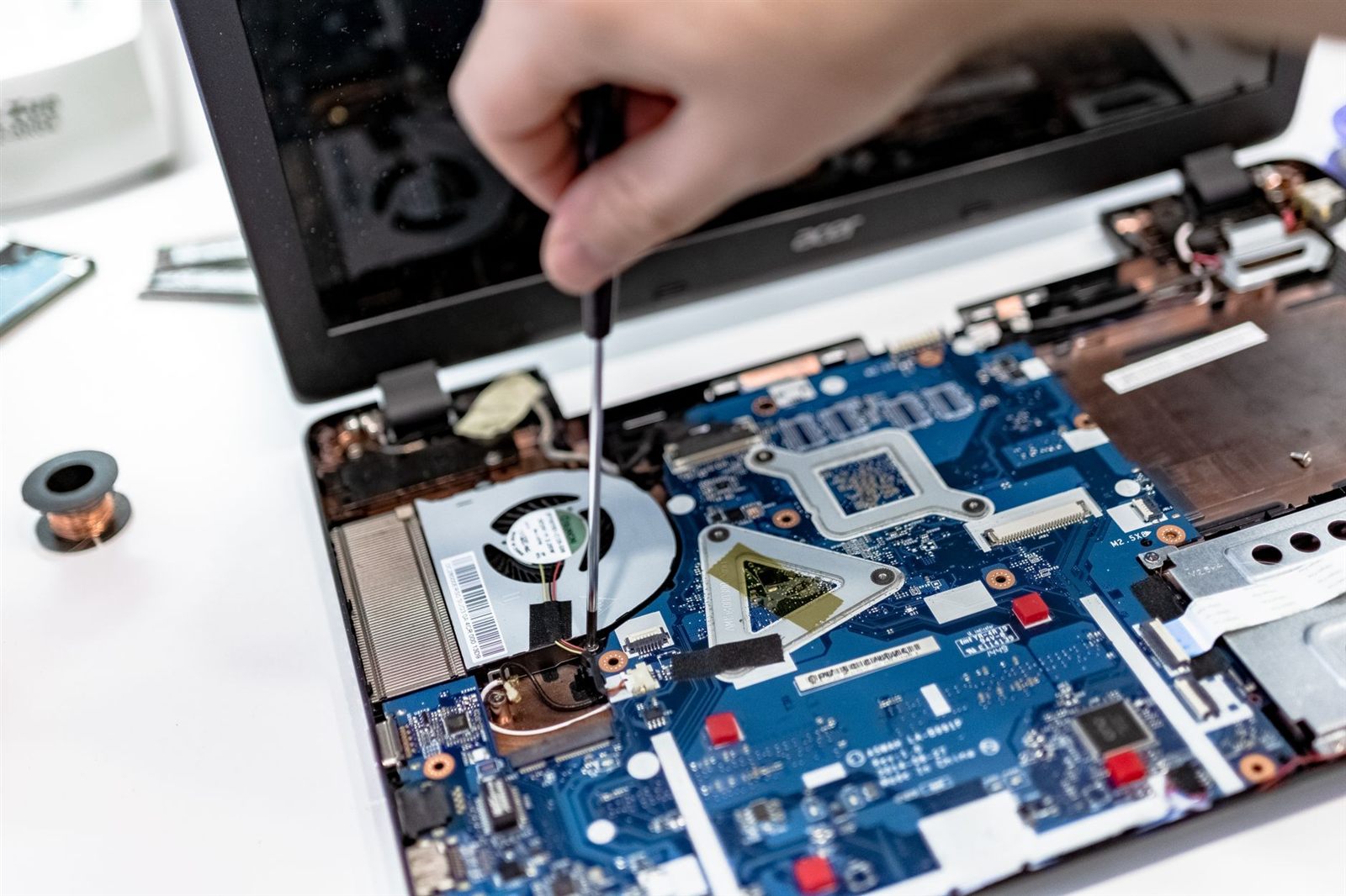 laptop repair precision tools nz technician using a precision screwdriver inside an open laptop during refurbished laptop servicing in nz