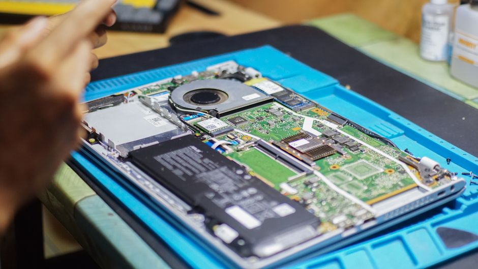 refurbished laptop renewal bench nz a modern slim laptop open on the hungrypc repair bench during renewal, with nvme ssd storage visible